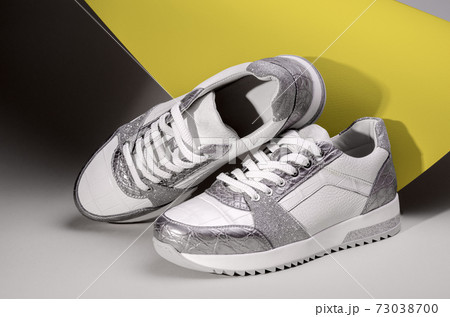 Pair of fashion sneakers shoes in ultimate gray and illuminating yellow colors of the year 2021. 73038700