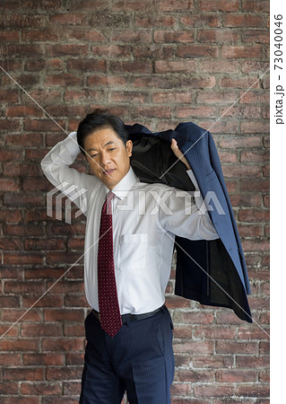 スーツに袖を通す50代ビジネスマン の写真素材