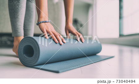 Yoga at home active lifestyle woman rolling exercise mat in living room for morning meditation yoga banner background 73040494