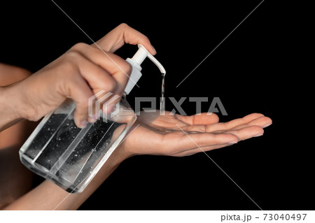 Coronavirus prevetion by using hand sanitizer when outside in public businesses. Woman putting gel in hands for protective measure against corona virus 73040497