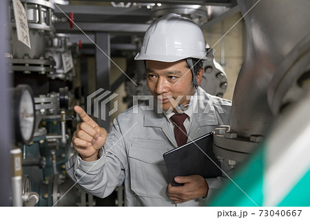 工場施設で設備メンテナンスをするビジネスマン 工場施設で設備メンテナンスをするビジネスマン 73040667