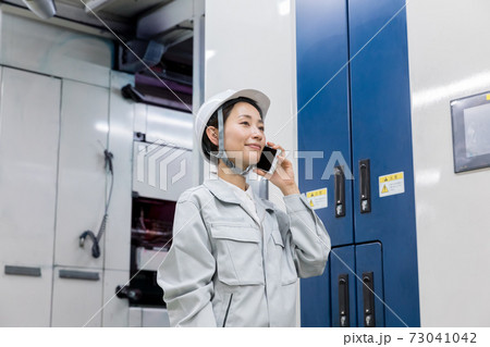 工場内でスマートフォンを使う女性 工場内でスマートフォンを使う女性 73041042