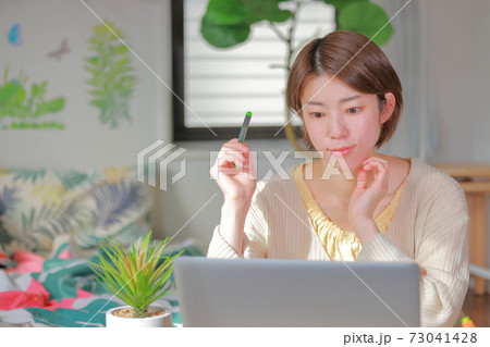 テレワーク_ペンを持ちにこやかな表情の女性 テレワーク_ペンを持ちにこやかな表情の女性 73041428