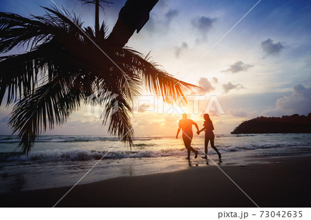 Teenage couple running on the beach Teenage couple running on the beach 73042635