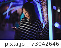 Asian young girl using a mobile phone in downtown 73042646