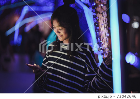 Asian young girl using a mobile phone in downtown Asian young girl using a mobile phone in downtown 73042646