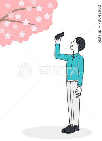 Man taking a picture of cherry blossoms 73043602