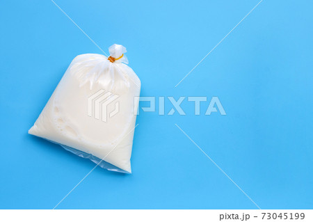 Soymilk in plastic bag on blue background. Top view 73045199