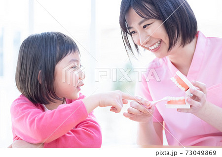 歯医者 歯磨き指導を受ける女の子と医師 歯医者 歯磨き指導を受ける女の子と医師 73049869