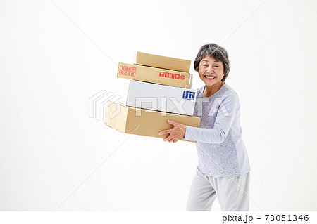 ネットショッピング 荷物を持つシニア女性の写真素材