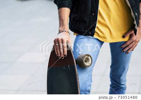 Close up of diversity young teenager concept with young teenager holding skate board and have black nails colored - casual and trendy people outdoor with alternative transport 73051480