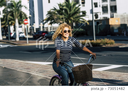 Cheerful people caucasian woman smile and enjoy bike ride in outdoor leisure activity in the city - active female have fun and have active lifestyle transportation concept free 73051482