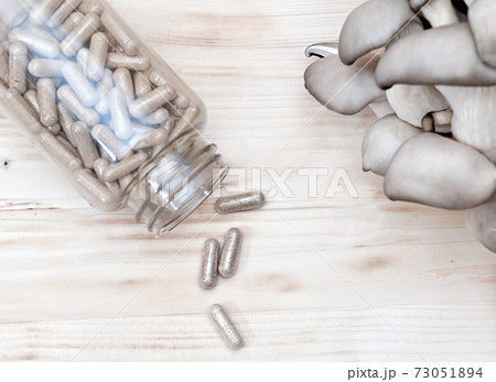 mushrooms and a bottle with mushroom capsules supplement 73051894