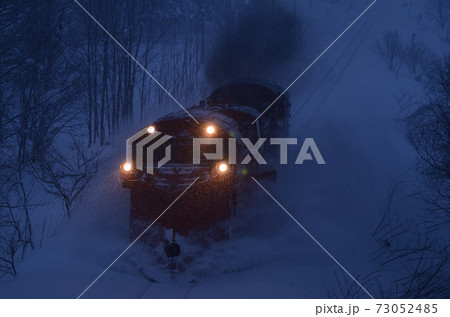 夕闇の宗谷本線で除雪するラッセル車 73052485