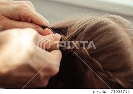 Mom is combing her daughter's hair. Taking care of baby's hair. The concept of a happy childhood and a good attitude towards children. Happy family Mom is combing her daughter's hair. Taking care of baby's hair. The concept of a happy childhood and a good attitude towards children. Happy family 73052719