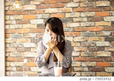 カフェで肌荒れを気にする女性 73053432