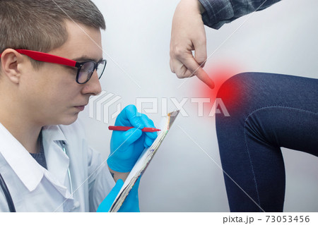 A woman suffers from knee pain. Examination by an orthopedist and traumatologist. Redness and swelling of the legs, torn meniscus or knee bursitis. The doctor examines 73053456