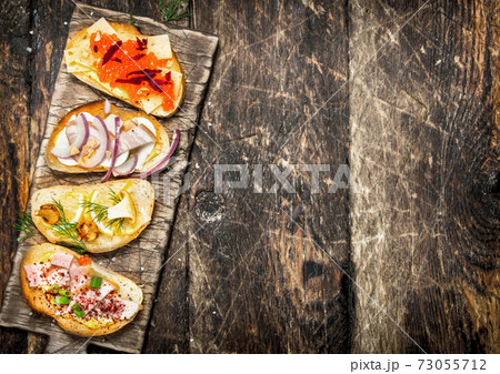 Sandwiches with mushrooms, salami, red caviar and fresh vegetables on toasted bread. 73055712