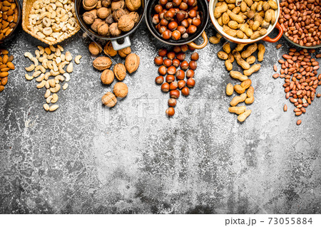 A lot of nuts in different bowls. A lot of nuts in different bowls. 73055884