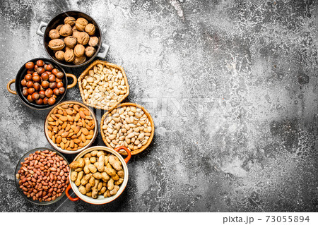A lot of nuts in different bowls. 73055894