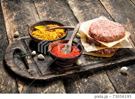 Raw burger with spices and herbs. 73056195