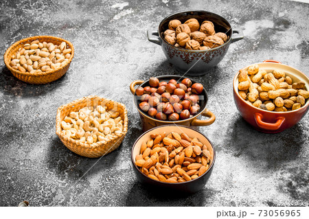 A lot of nuts in different bowls. A lot of nuts in different bowls. 73056965