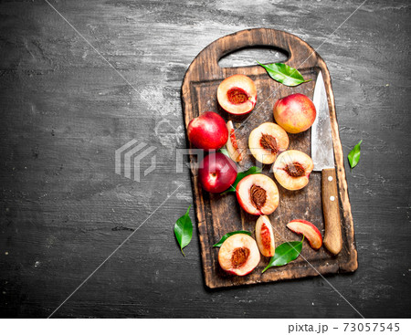 Ripe peaches on a cutting Board with a knife. 73057545