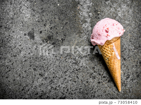 Strawberry ice cream in a waffle cup. 73058410