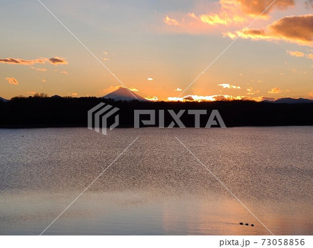 夕日が沈む多摩湖と富士山 73058856