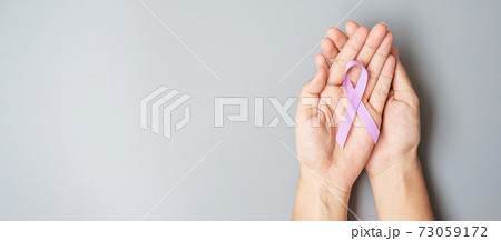 World cancer day (February 4). Woman hand hoy Lavender purple ribbon for supporting people living and illness. Healthcare and medical concept World cancer day (February 4). Woman hand hoy Lavender purple ribbon for supporting people living and illness. Healthcare and medical concept 73059172