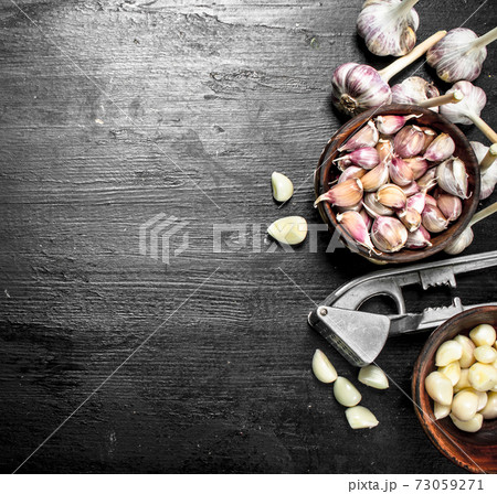 Peeled garlic cloves with press tool. Peeled garlic cloves with press tool. 73059271