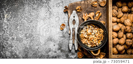 Shelled walnuts in bowl with Nutcracker Shelled walnuts in bowl with Nutcracker 73059471