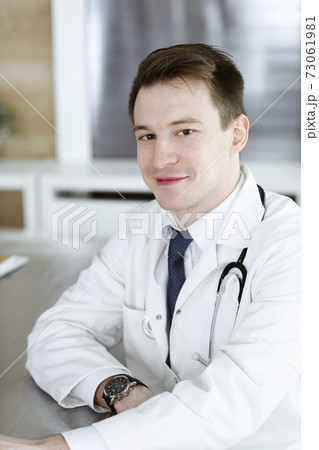 Doctor man sitting behind a computer at workplace in clinic or hospital office. Medic headshot and medicine concept 73061981