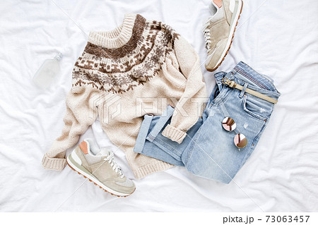 Female fashion look with stylish clothes and accessories. Women's warm sweater, jeans, sneakers. Modern and casual outfit. Flat lay, top view. Female fashion look with stylish clothes and accessories. Women's warm sweater, jeans, sneakers. Modern and casual outfit. Flat lay, top view. 73063457
