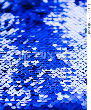 Bright shiny texture of colorful sequins in blue and purple colors. Fashion fabric background. 73065121