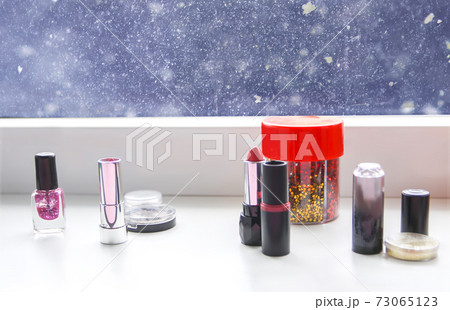 Bright composition of fashion accessories. Lipsticks, nail polish and tinsel. Objects on soft pastel background. Flat lay, top view Bright composition of fashion accessories. Lipsticks, nail polish and tinsel. Objects on soft pastel background. Flat lay, top view 73065123