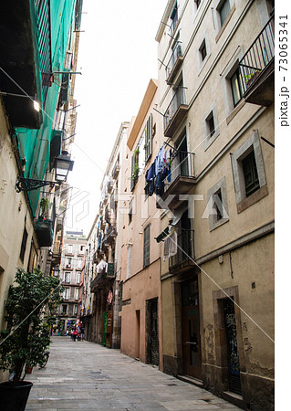 スペインバルセロナの街並み 石畳の細道の両脇に建つ歴史的な石造りの建物の写真素材
