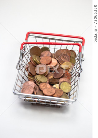 Iron shopping basket filled with euro coins isolated on white background, business and financial concept Iron shopping basket filled with euro coins isolated on white background, business and financial concept 73065350