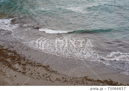 Photography of the Atlantic Ocean surf in the Bay of Biscay. Waves running onto the sandy shore in summer day. Natural fresh background for poster, banner, postcard, greeting card, touristic guide Photography of the Atlantic Ocean surf in the Bay of Biscay. Waves running onto the sandy shore in summer day. Natural fresh background for poster, banner, postcard, greeting card, touristic guide 73066657
