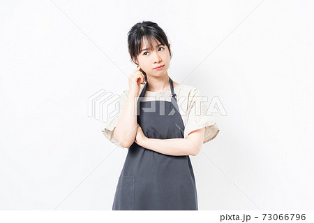 考え事をするエプロンを着た若い女性 考え事をするエプロンを着た若い女性 73066796