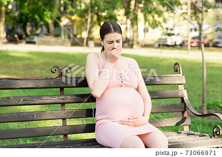 pregnant woman suffering from toxicosis in the park pregnant woman suffering from toxicosis in the park 73066971