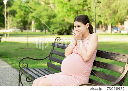 pregnant woman suffering from toxicosis in the park pregnant woman suffering from toxicosis in the park 73066972