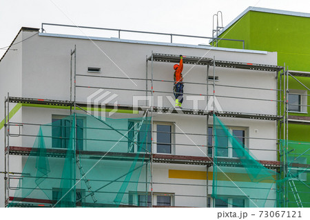 demolition of scaffolding after thermal insulation and painting of the facade of an apartment house 73067121