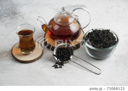 A glass teapot with tea on a wooden board 73068123