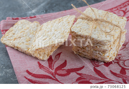 Stack of tasty crispbread on red cloth 73068125