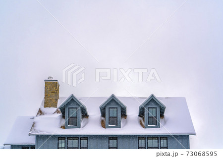 Snow covered roof of home against sky in December Snow covered roof of home against sky in December 73068595