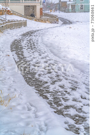 Road blanketed with snow along homes in Daybreak 73068661