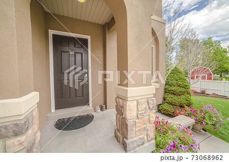 Porch and front door of modern house with garden 73068962