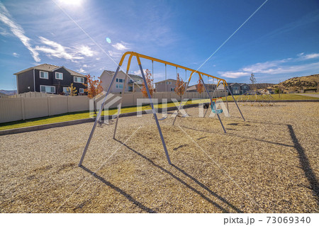 A-frame kids swings in a gravelled playground A-frame kids swings in a gravelled playground 73069340