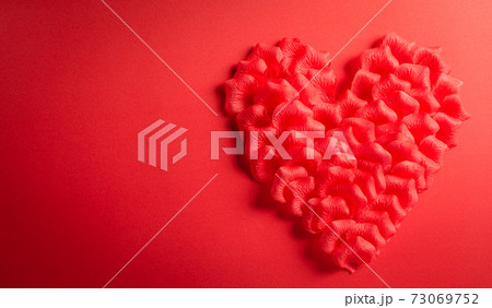 Love and Valentine's day concept. Red hearts made from rose petals on red paper background. Flat lay top view. 73069752